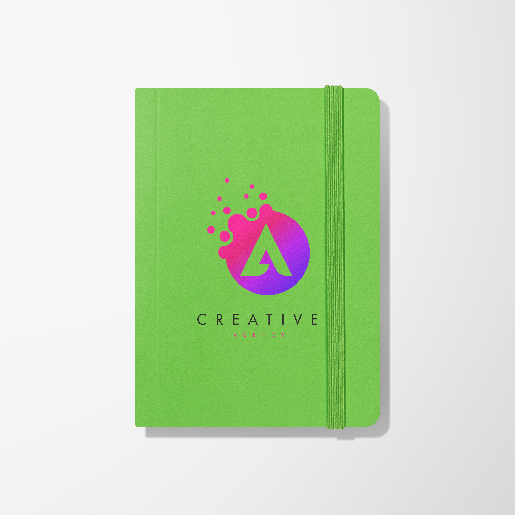 Green promotional notebook with pen displaying a multicolor imprint.